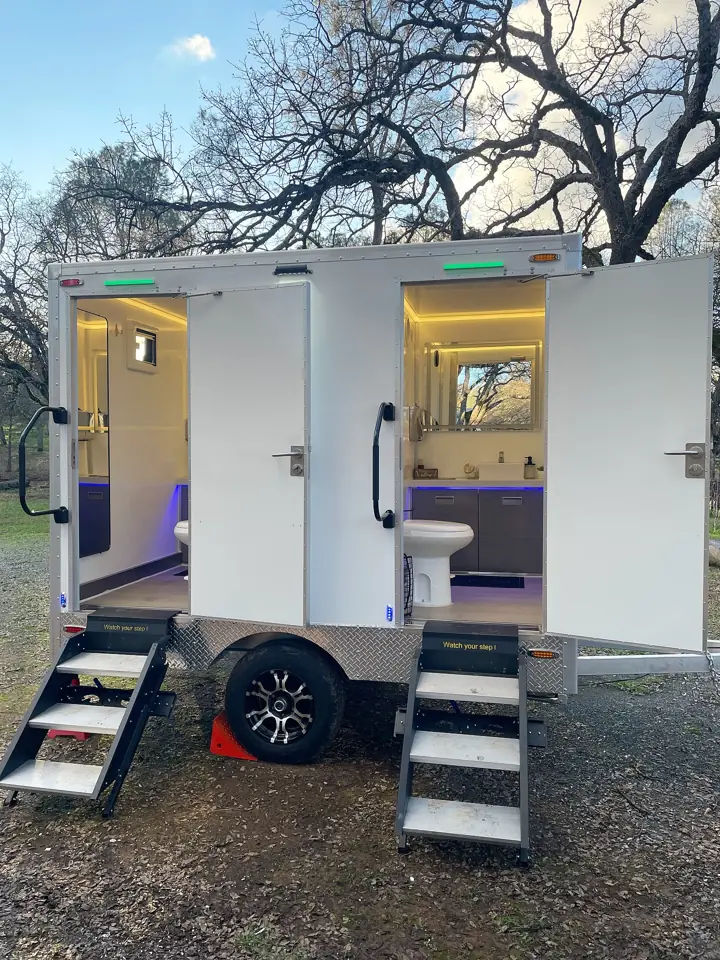 Luxury restroom trailer with both doors open and lit interiors